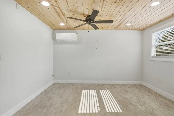 an empty room with a window and a ceiling fan