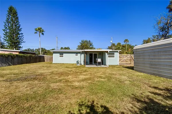 a backyard of a house with table and chairs