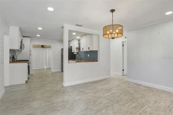a view of a kitchen with stainless steel appliances granite countertop cabinets a refrigerator and a view of living room