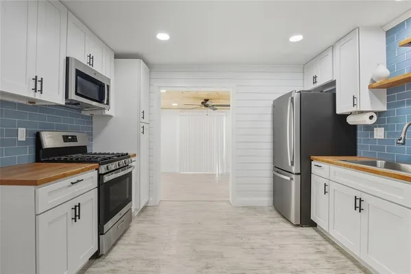 a kitchen with stainless steel appliances granite countertop a refrigerator stove and sink