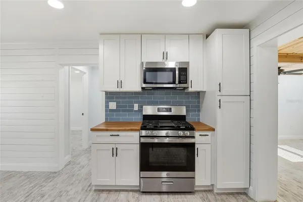 a kitchen with stainless steel appliances a stove a microwave and cabinets