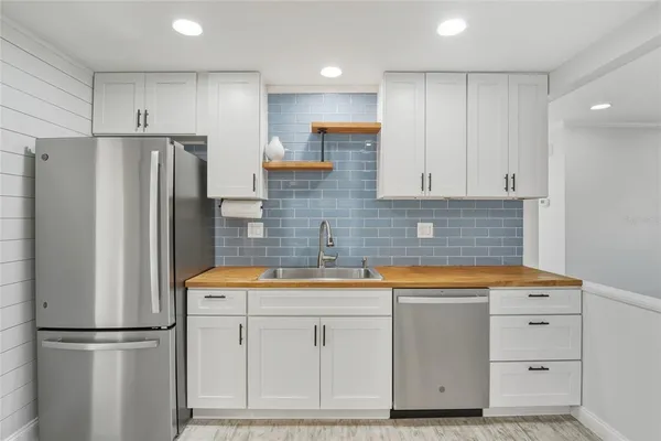 a kitchen with white cabinets and refrigerator