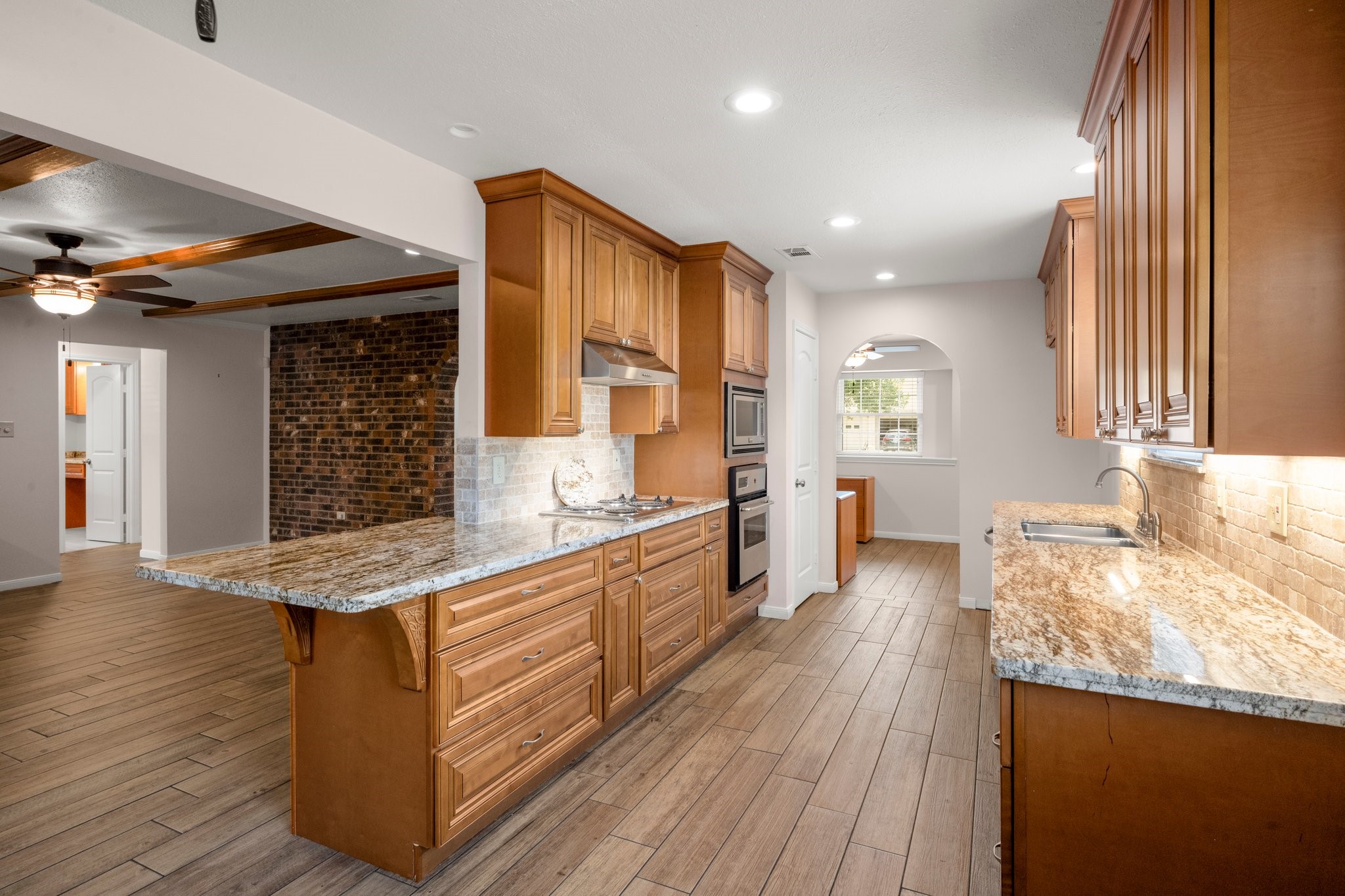 1206 Lynwood Road Spring, TX 77373 - Photo 14 of 29 a large kitchen with kitchen island granite countertop wooden floors and wide window