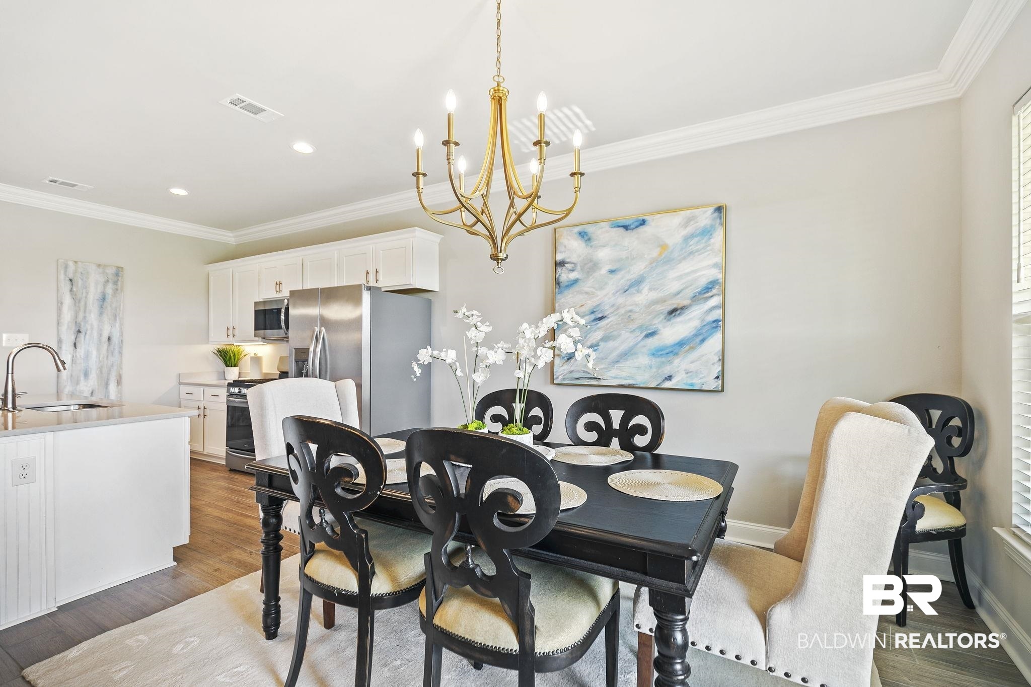10140 Chipper Lane Foley, AL 36535 - Photo 16 of 72 Dining space with sink, an inviting chandelier, ornamental molding, and dark hardwood / wood-style flooring