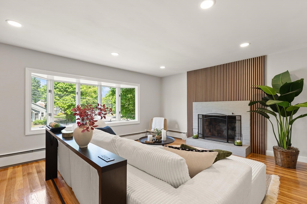 1049 Pleasant Street Canton, MA 02021 - Photo 2 of 16 a living room with furniture a fireplace and a floor to ceiling window