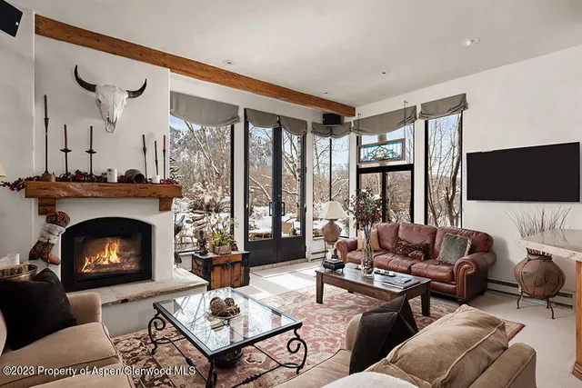 a living room with furniture a fireplace and a flat screen tv