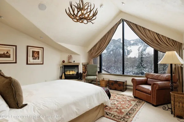 a bedroom with a bed a couch and a large window