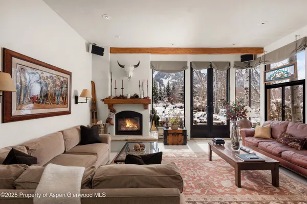 a living room with furniture a large window and a fireplace