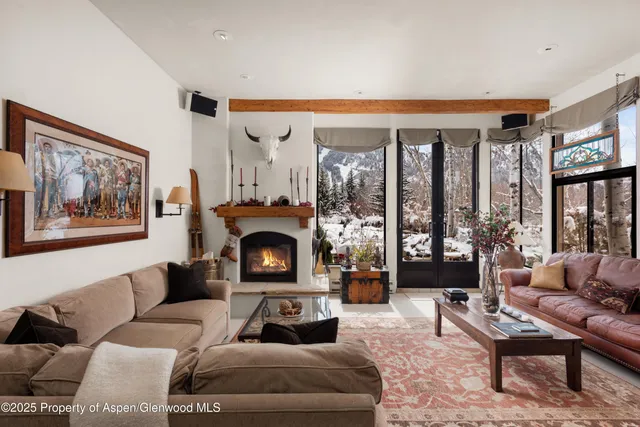 a living room with furniture a large window and a fireplace