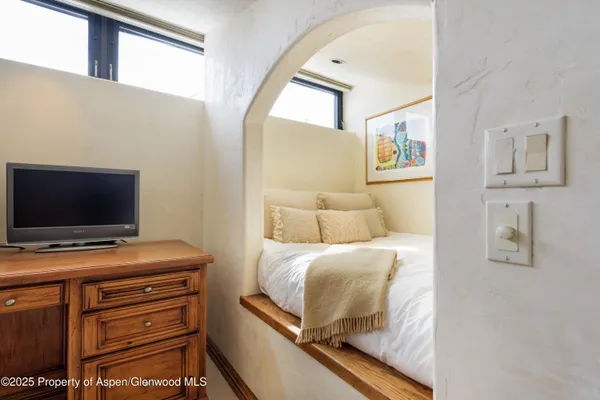 a bedroom with a bed and a flat screen tv