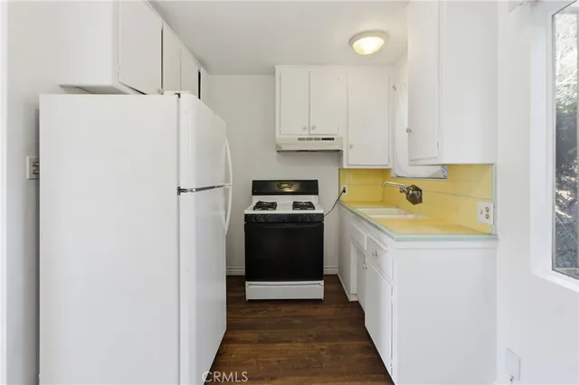 a kitchen with a refrigerator sink and cabinets