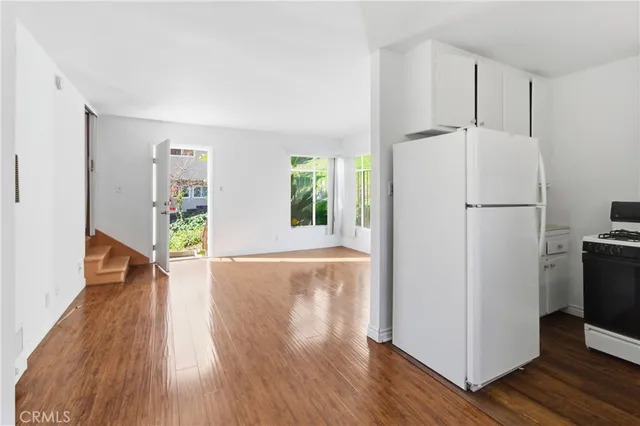 a view of a kitchen with wooden floor and a refrigerator
