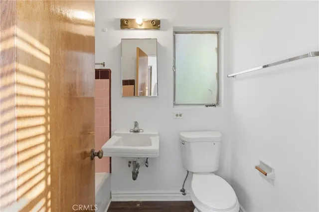 a bathroom with a toilet a sink and mirror