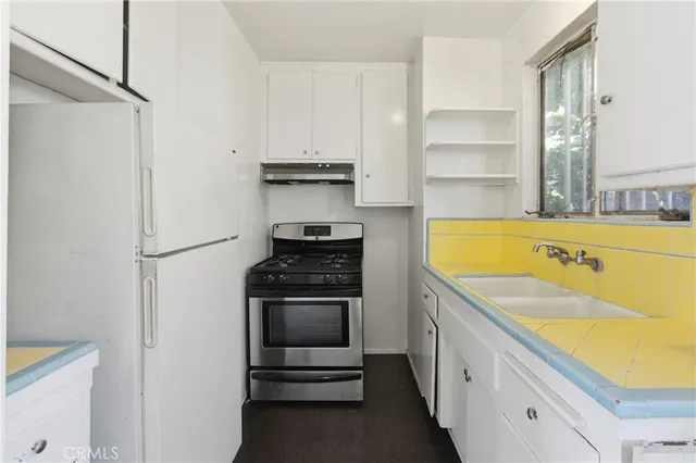 a kitchen with a sink stove and refrigerator