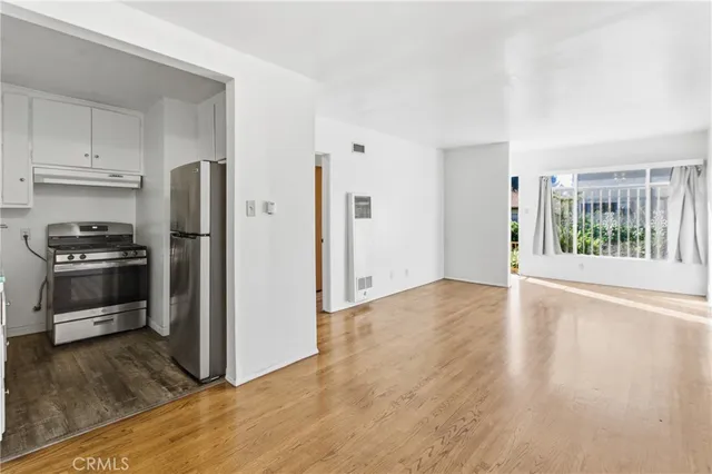 a view of a kitchen with a stove fridge and wooden floor