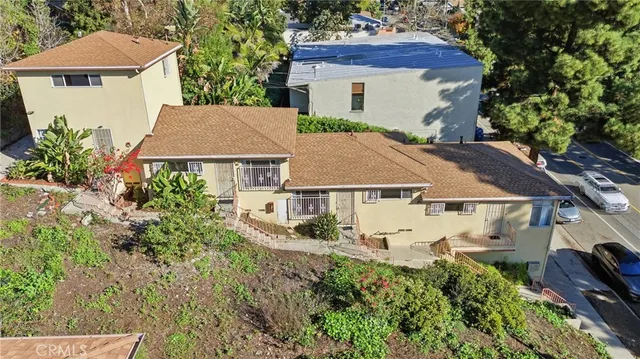 an aerial view of a house with yard and a table and chairs under an umbrella