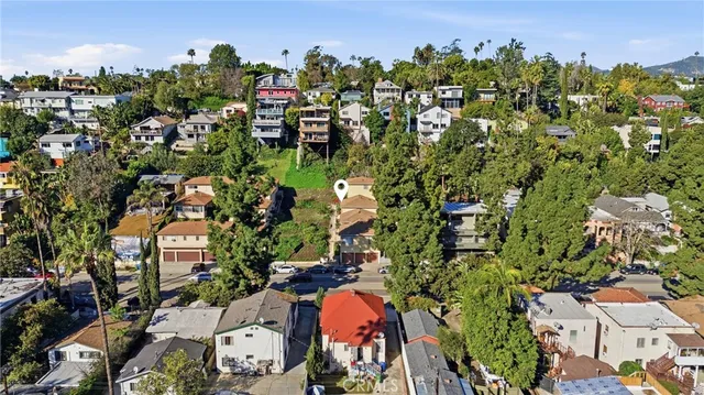 an aerial view of residential house with outdoor space and trees all around