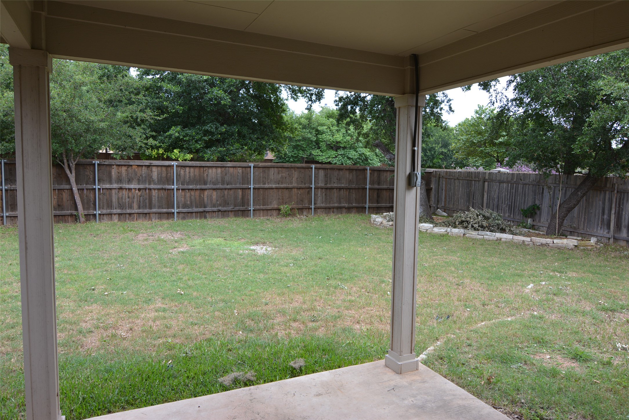1303 Horseshoe Ranch Drive Leander, TX 78641 - Photo 23 of 26 A spacious backyard enclosed by a wooden privacy fence, offering a verdant retreat.