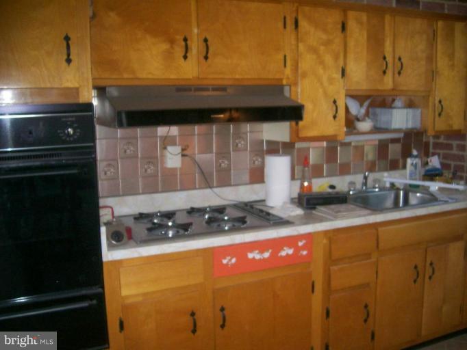 507 Brisbane Road Baltimore, MD 21229 - Photo 8 of 11 a kitchen with stainless steel appliances granite countertop a stove a sink and a microwave