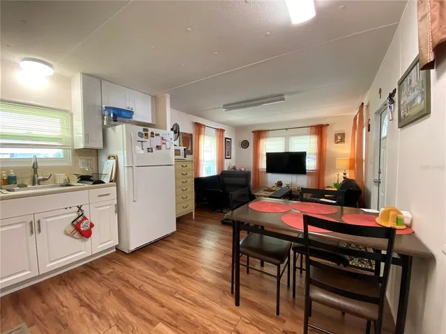 a room with a table chairs and a refrigerator
