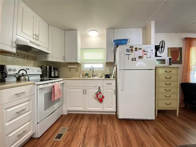a kitchen with white cabinets and white appliances