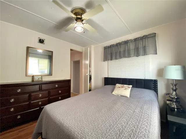 a bedroom with a bed and a flat tv screen on the dresser