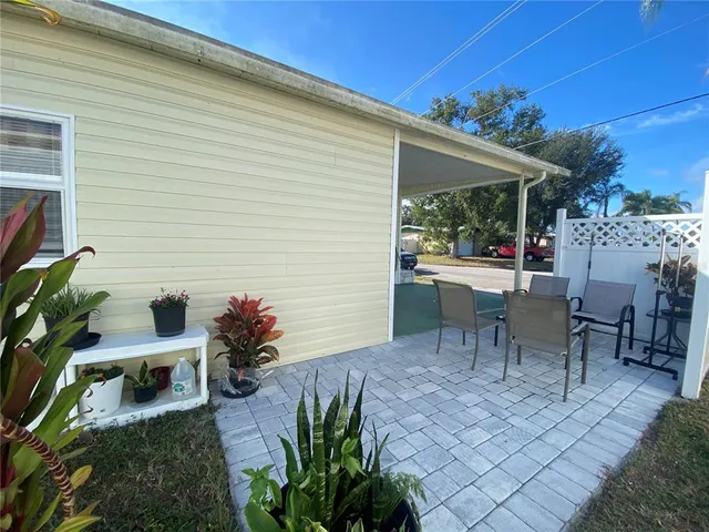 a view of a patio with table and chairs potted plants
