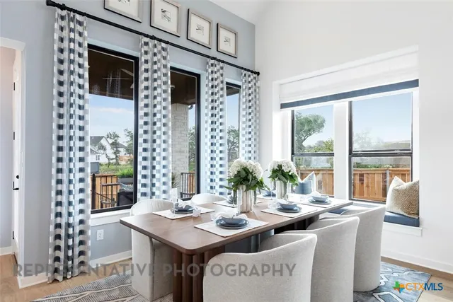 a view of a dining room with furniture large windows and a chandelier