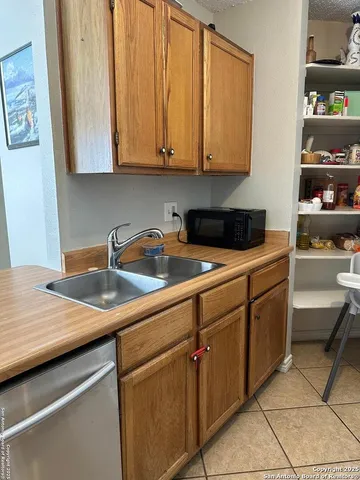 a kitchen with stainless steel appliances granite countertop a sink and a white cabinets