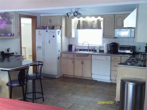 275 Andover Road Billerica, MA 01821 - Photo 3 of 26 a kitchen with a table chairs refrigerator and microwave