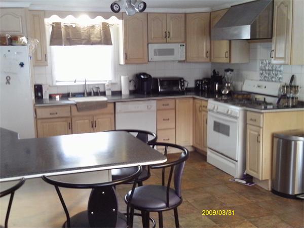 275 Andover Road Billerica, MA 01821 - Photo 5 of 26 a kitchen with stainless steel appliances kitchen island a table chairs in it and wooden floors