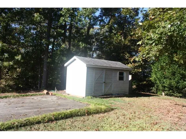 a view of wooden house with a yard
