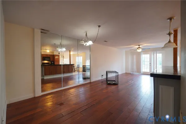 a view of a room with wooden floor and a kitchen