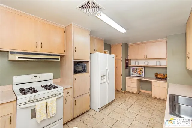a kitchen with a stove a refrigerator and a sink