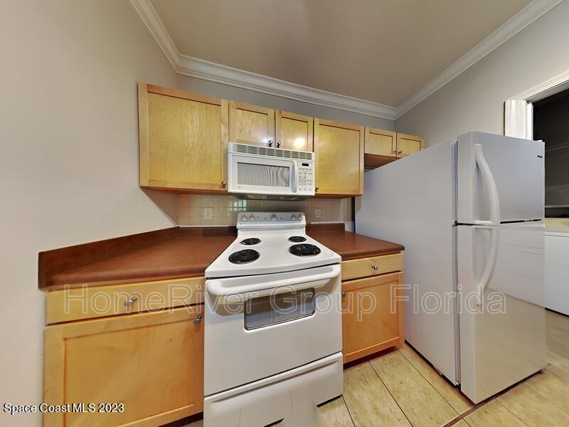 6450 Borasco Drive, Unit 3703 Melbourne, FL 32940 - Photo 13 of 13 a kitchen with a stove top oven and a refrigerator