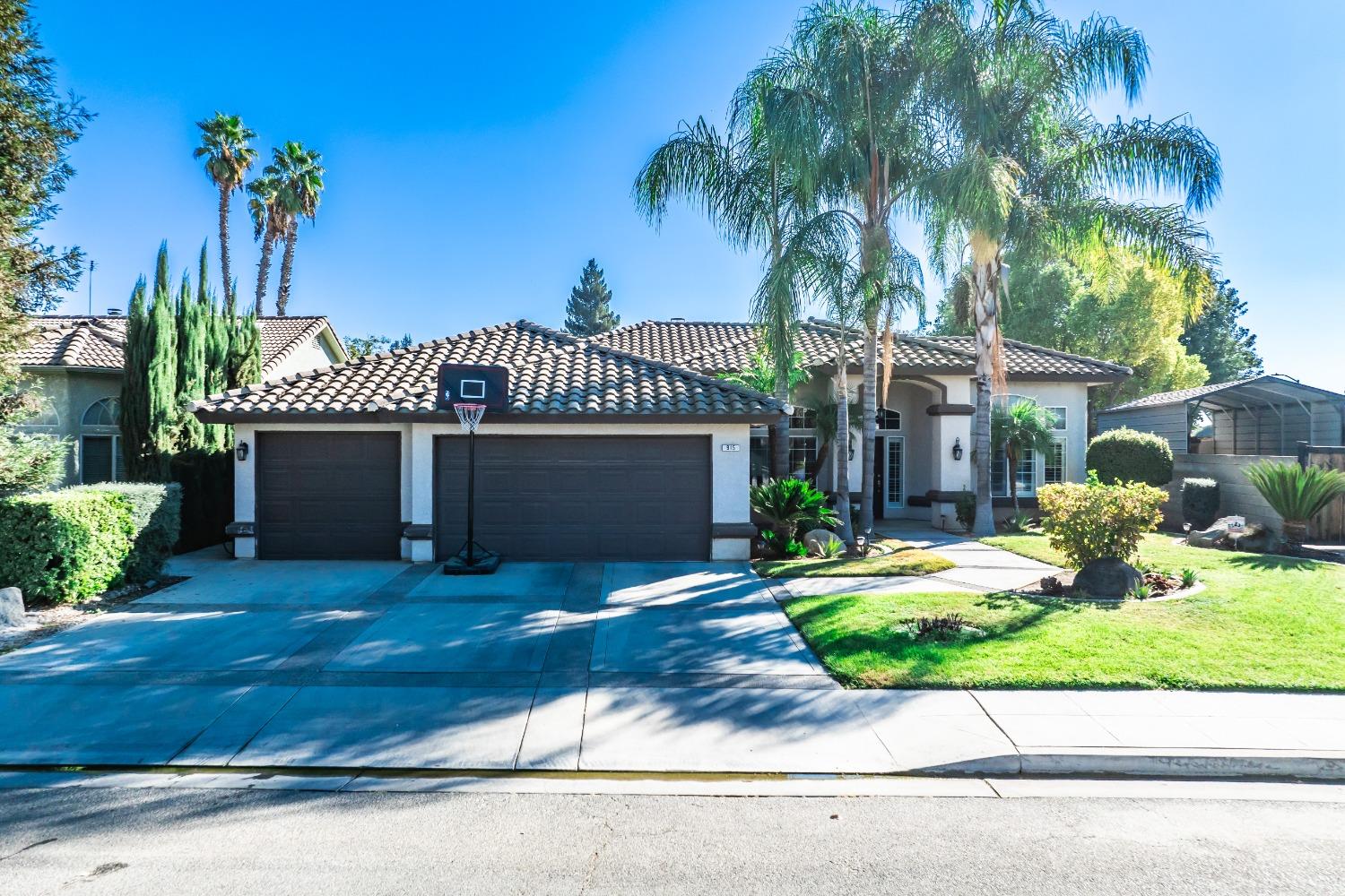 a front view of a house with a yard and potted plants