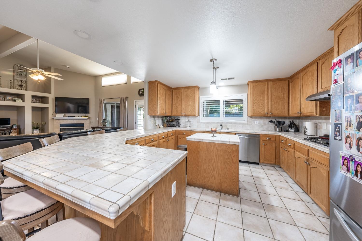 915 Trabon Way Madera, CA 93637 - Photo 11 of 33 a large kitchen with kitchen island a large counter space a sink appliances and cabinets
