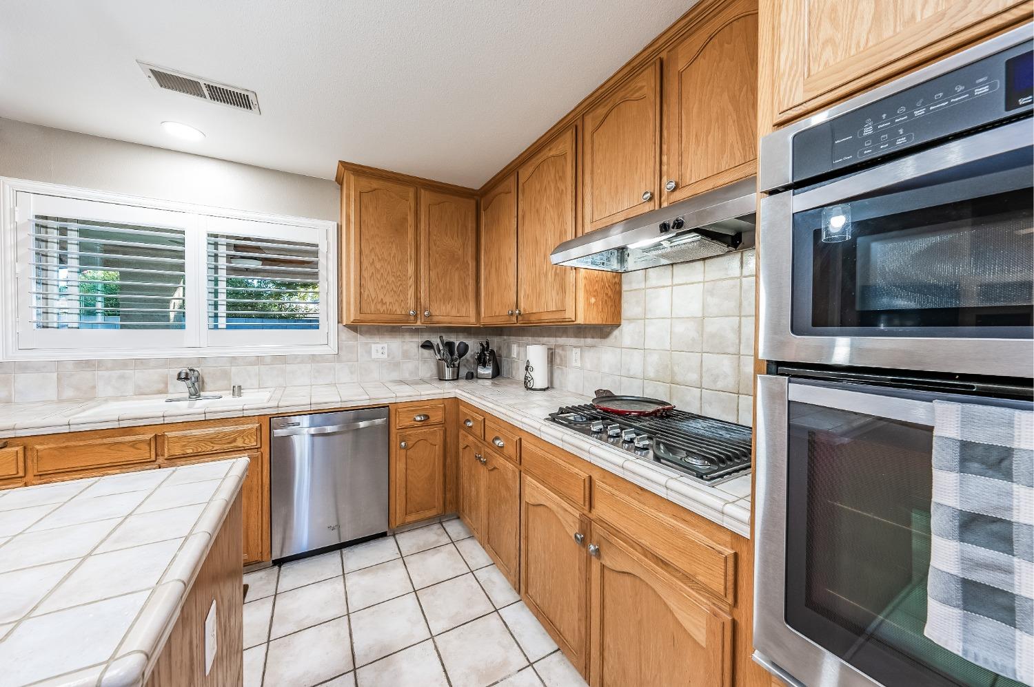 915 Trabon Way Madera, CA 93637 - Photo 12 of 33 a kitchen with stainless steel appliances granite countertop a stove a sink and a microwave