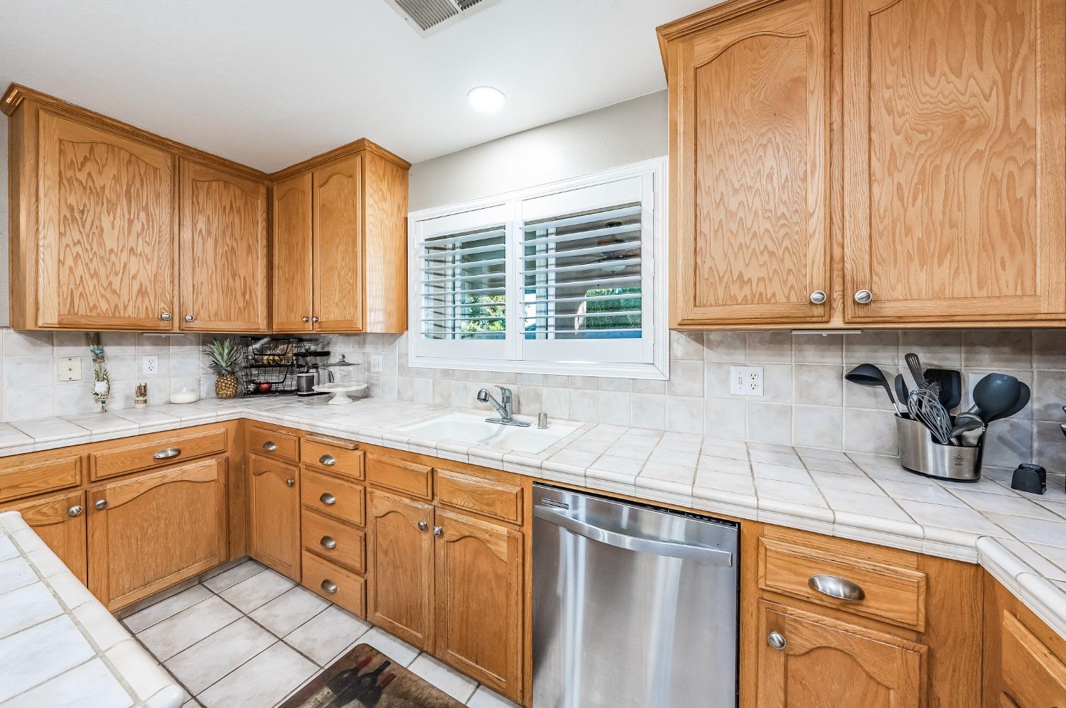 915 Trabon Way Madera, CA 93637 - Photo 13 of 33 a kitchen with stainless steel appliances granite countertop a sink a stove and cabinets