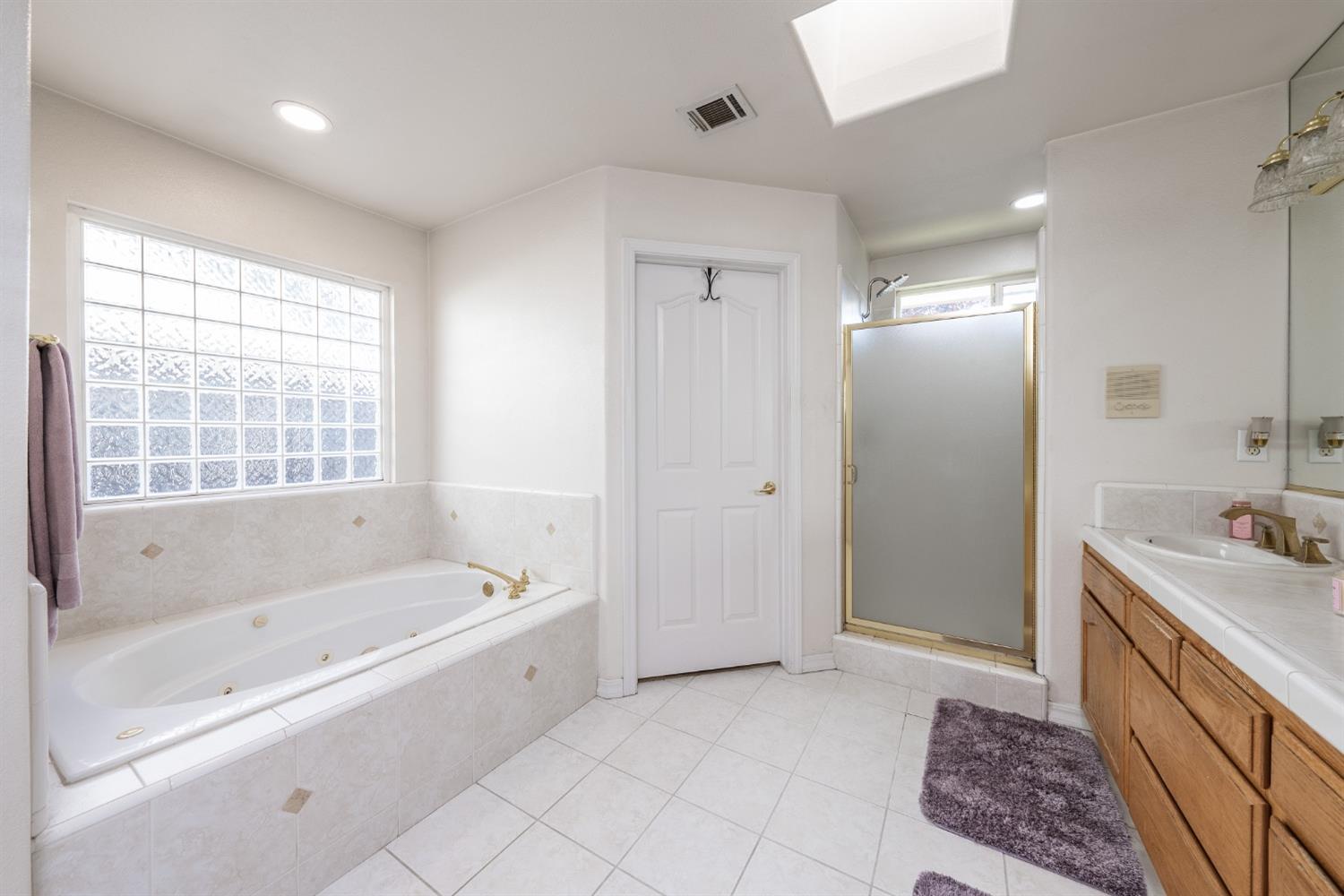 915 Trabon Way Madera, CA 93637 - Photo 19 of 33 a spacious bathroom with a tub sink and mirror