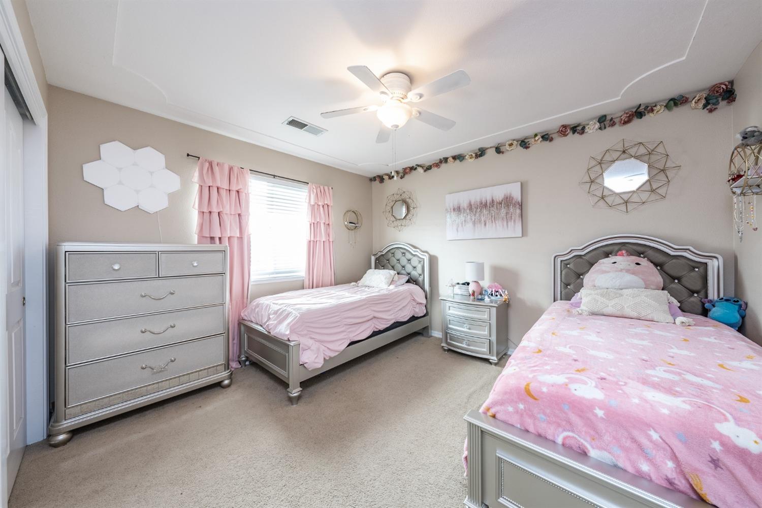 915 Trabon Way Madera, CA 93637 - Photo 21 of 33 a bedroom with two beds and a chandelier
