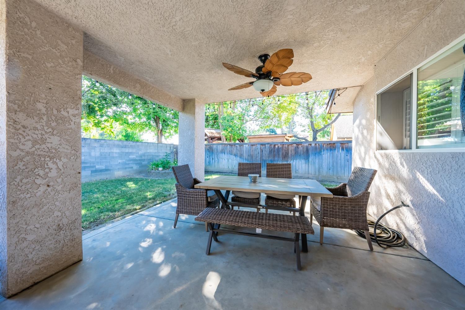 915 Trabon Way Madera, CA 93637 - Photo 23 of 33 a view of a patio with a table chairs and a yard
