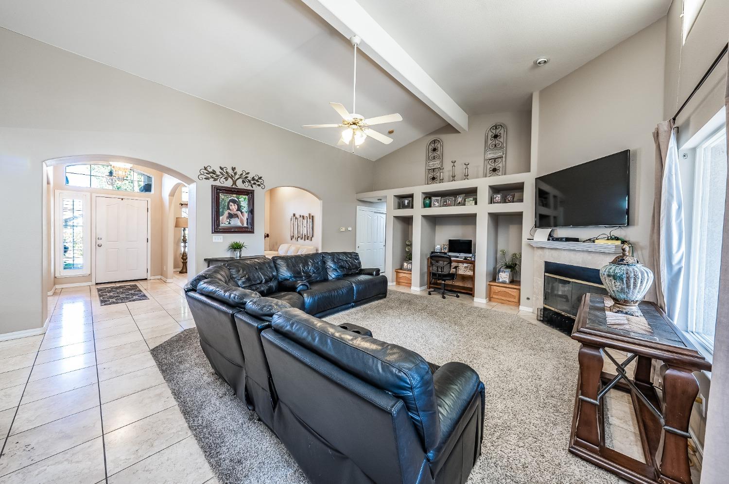 915 Trabon Way Madera, CA 93637 - Photo 9 of 33 a living room with furniture a flat screen tv and kitchen view