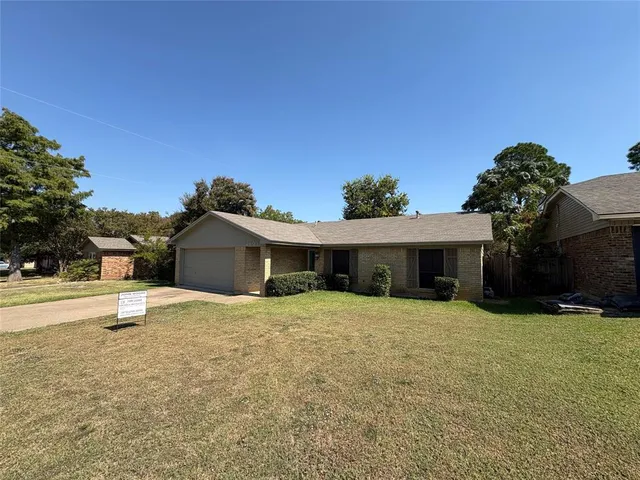 a white house with a yard and a large tree