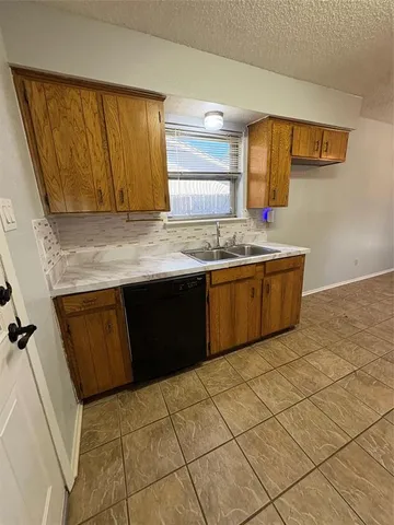 a kitchen with a sink a window and cabinets