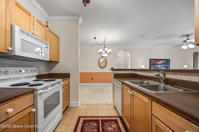 a kitchen with granite countertop stainless steel appliances a stove a sink and cabinets