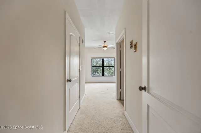 a view of an empty room with a ceiling fan and a window