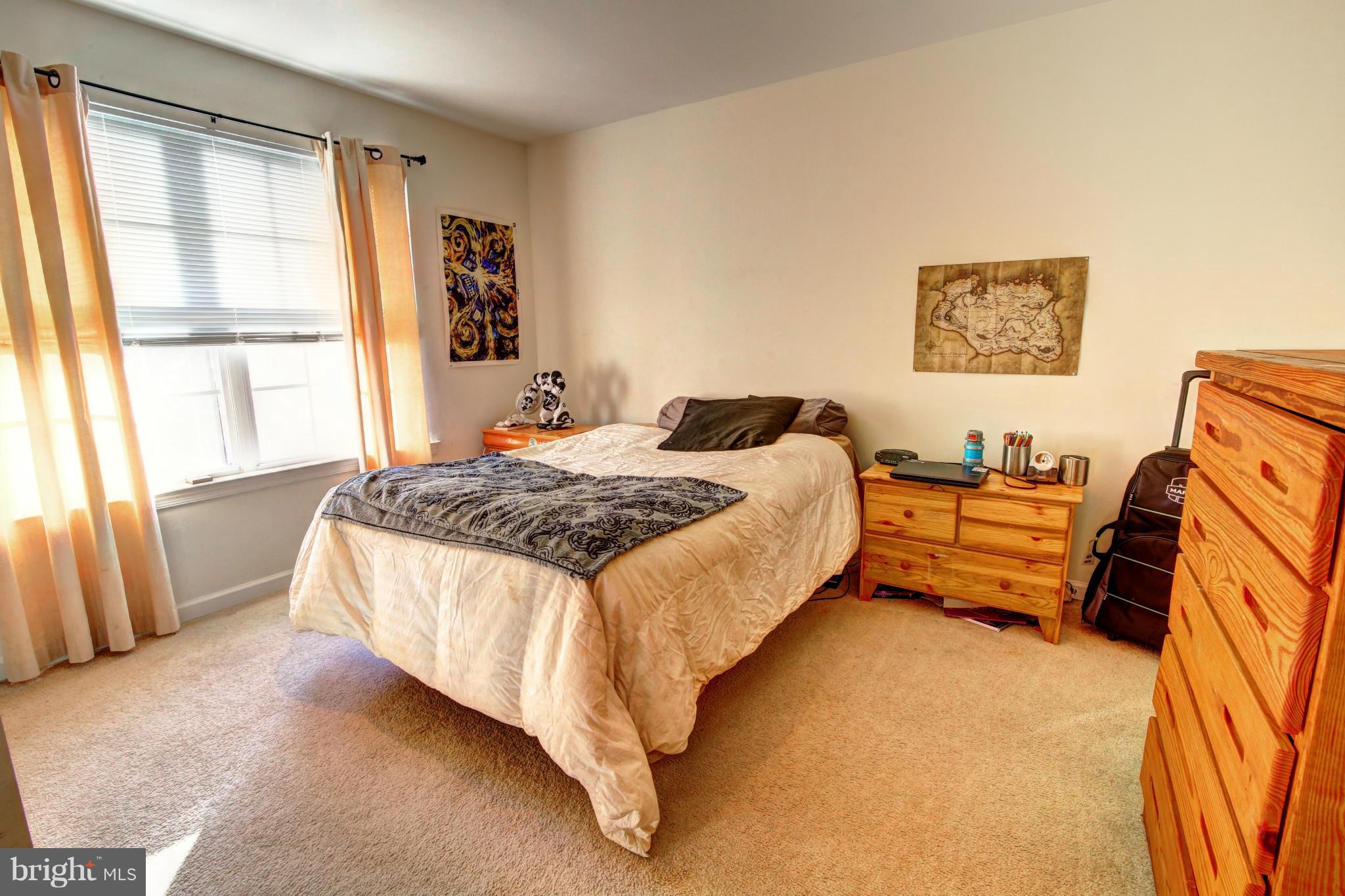 635 Constellation Square Southeast, Unit K Leesburg, VA 20175 - Photo 12 of 14 a bedroom with a bed and a couch next to a window