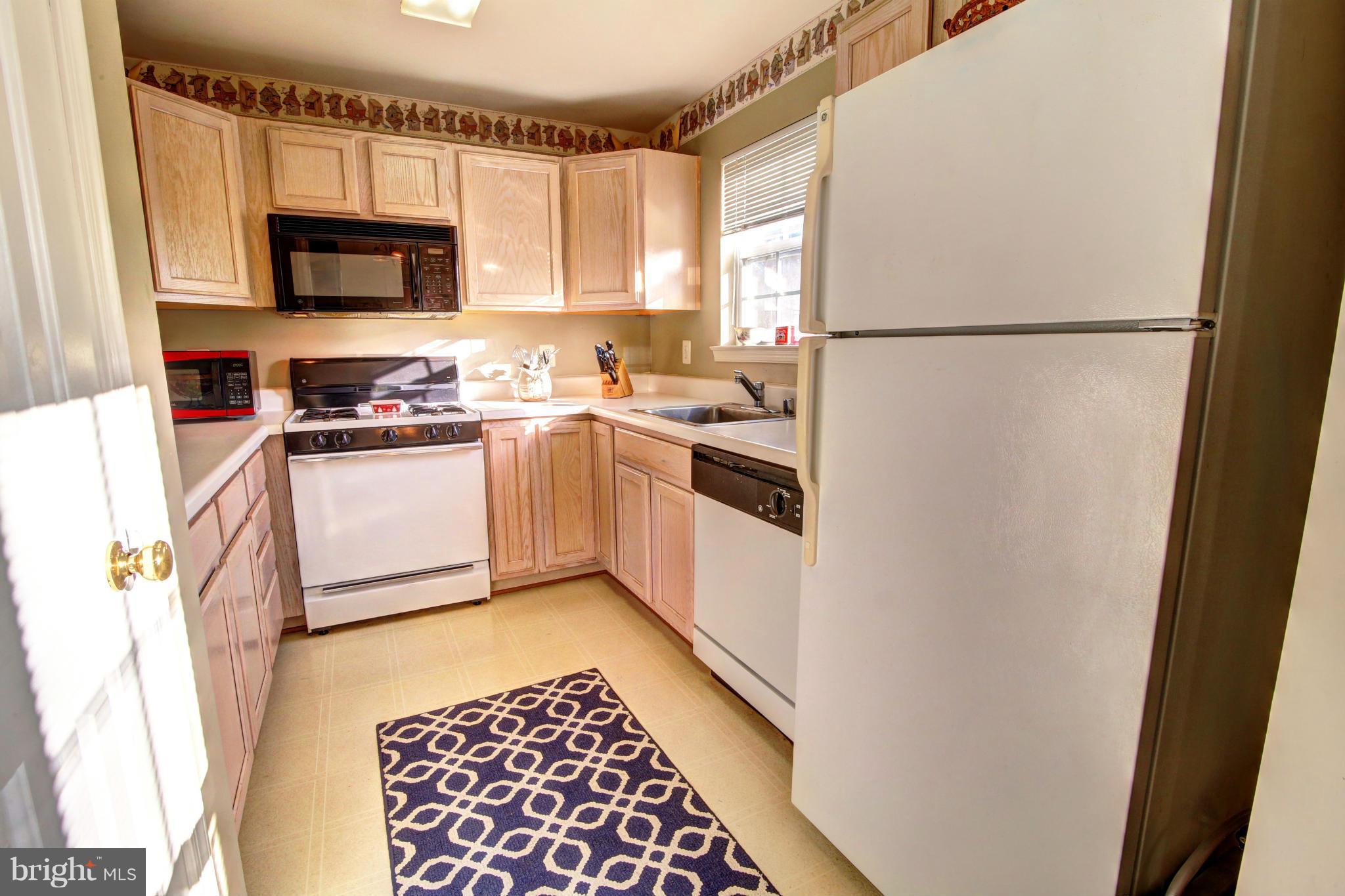 635 Constellation Square Southeast, Unit K Leesburg, VA 20175 - Photo 4 of 14 a kitchen with granite countertop a refrigerator stove and microwave