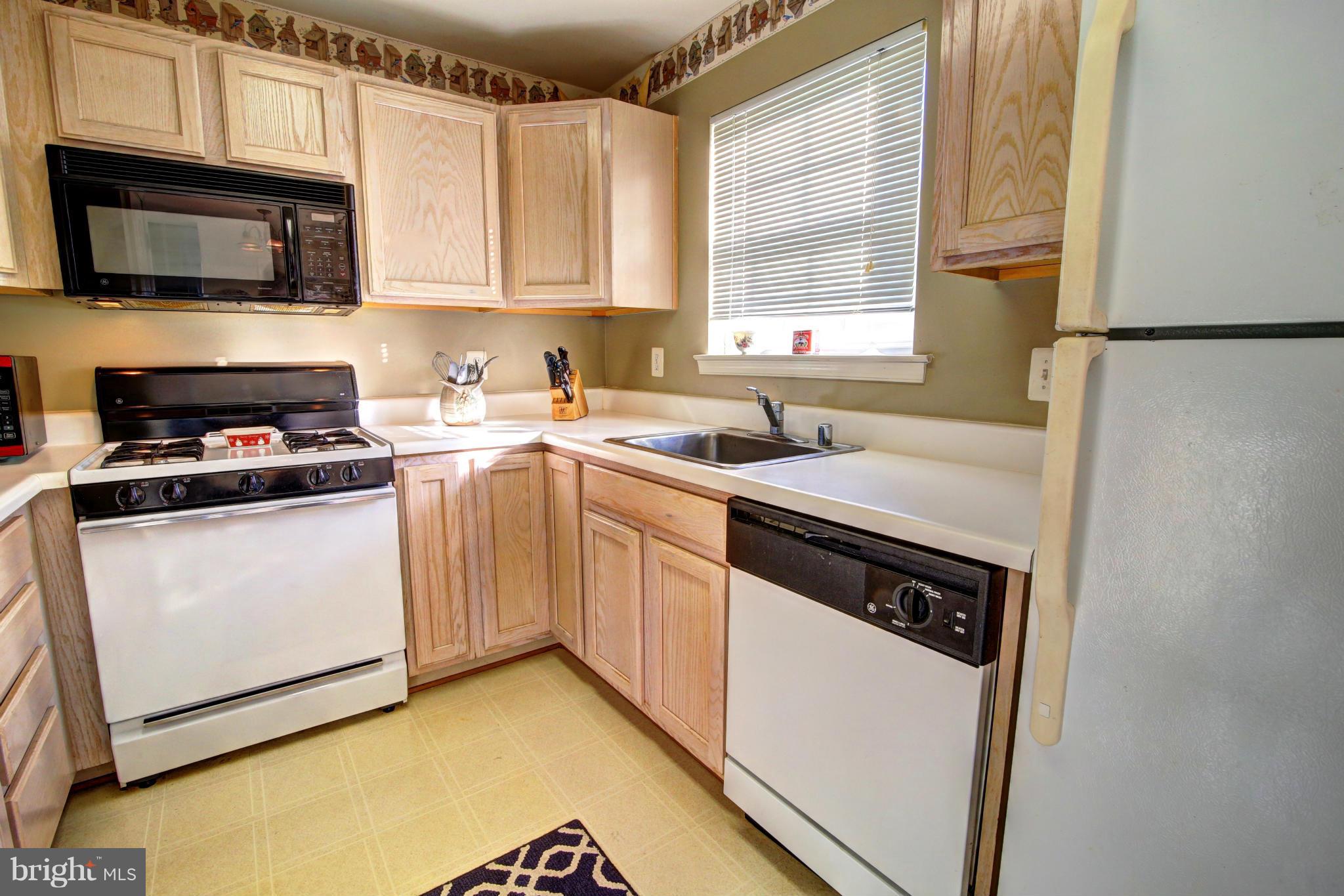 635 Constellation Square Southeast, Unit K Leesburg, VA 20175 - Photo 5 of 14 a kitchen with a stove a sink and a microwave